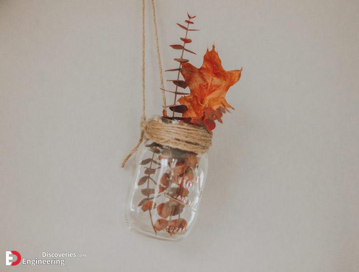 pot-en-verre-suspendu-sur-une-ficelle-aves-des-feuilles-d-automne-et-branches-d-automne-à-l-intérieur.jpg